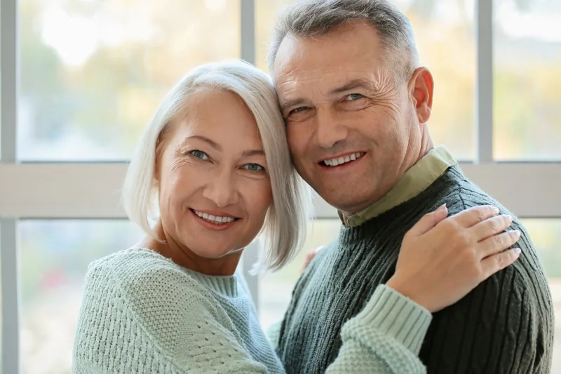 Photo to coloring page example: a real photo of an older couple smiling by a window